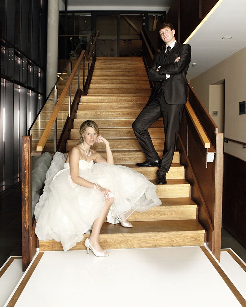 Hochzeitsfotografie von Braut und Bräutigam auf einer Holztreppe positioniert