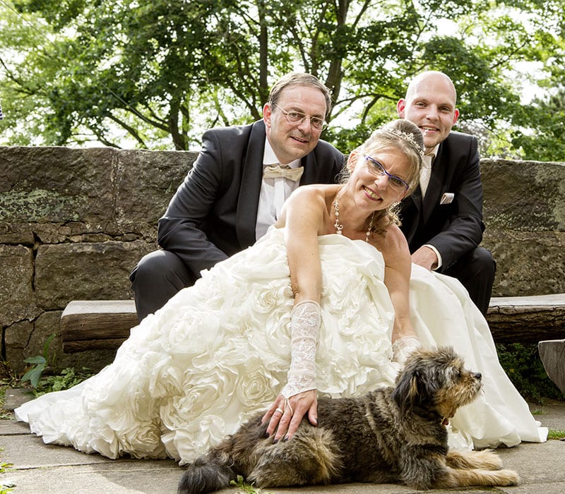 Hochzeitsfotografie mit Braut, Bräutigam und Gast mit kleinem Hund