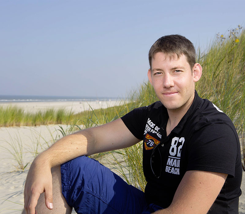 Portraitbilder eines jungen Mannes am Strand in der Sonne